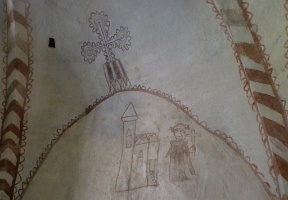 In this image a monk is stepping out from a church.